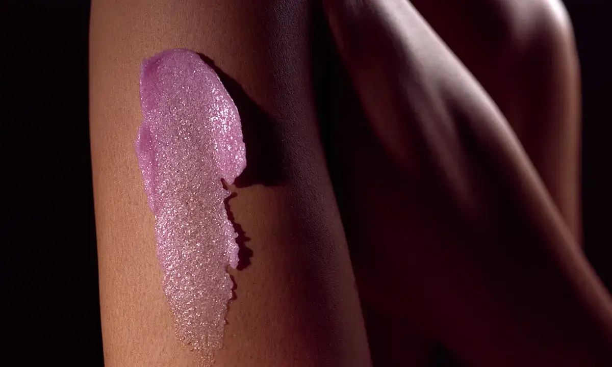 Różowy peeling na skórze nogi. Idealny peeling przed goleniem dla gładkości.