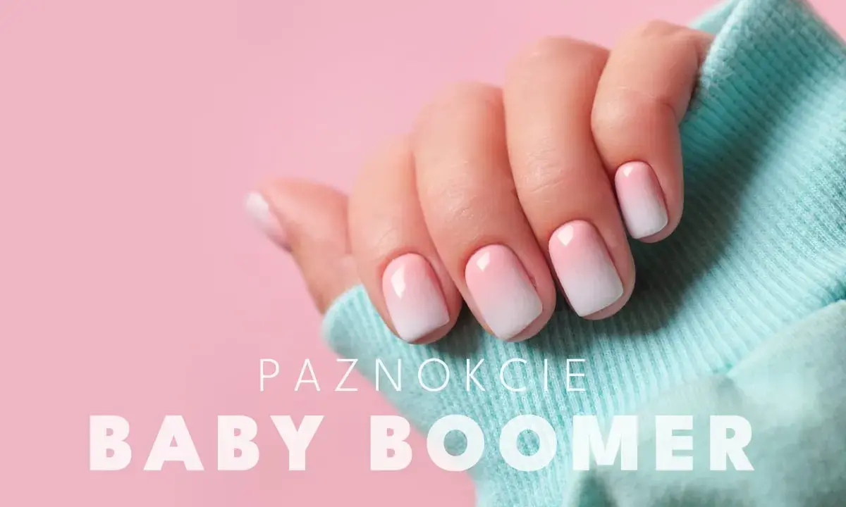 Dłoń z perfekcyjnym manicure baby boomer. Delikatne przejście od różu do bieli na paznokciach, otulona błękitnym materiałem.