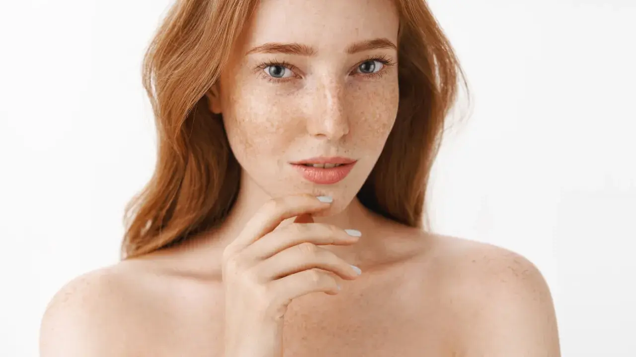 Ruda kobieta z piegami, których urok podkreśla naturalna produkcja melaniny.