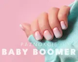 Dłoń z perfekcyjnym manicure baby boomer. Delikatne przejście od różu do bieli na paznokciach, otulona błękitnym materiałem.