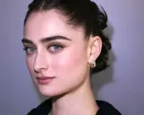 Wyrazista kość jarzmowa podkreśla delikatne rysy młodej kobiety o niebieskich oczach i subtelnym makijażu.