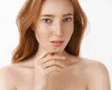 Ruda kobieta z piegami, których urok podkreśla naturalna produkcja melaniny.