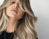 Kobieta z blond włosami i lekka grzywka na boki, podkreślająca jej delikatne rysy.