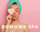 Kobieta z ręcznikiem na głowie i płatkami pod oczy, trzymająca serduszko. Czas na Twoje domowe spa.