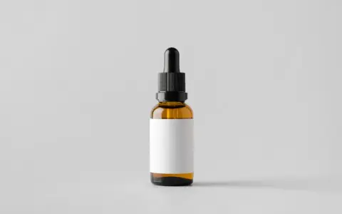 Brązowa buteleczka z pipetką, idealna na serum z witaminą E, np. tocopheryl acetate, z pustą białą etykietą.