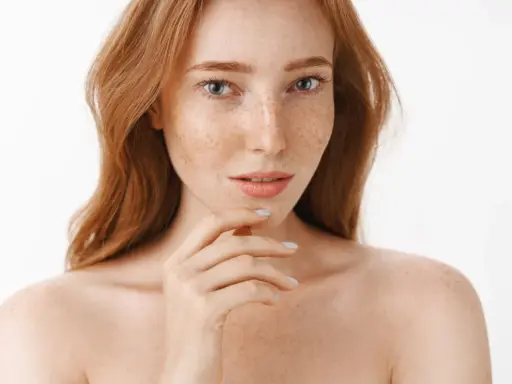 Ruda kobieta z piegami, których urok podkreśla naturalna produkcja melaniny.