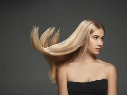 Blond włosy modelki falują, ukazując ich zdrową budowę.