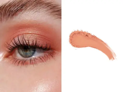 Delikatny makijaż oka w odcieniach brzoskwini, z subtelnym połyskiem. Obok próbka pudrowego różu, niczym delikatny **peach fuzz**.