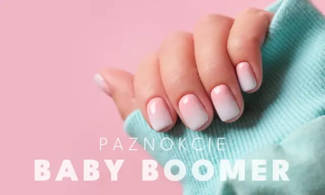 Dłoń z perfekcyjnym manicure baby boomer. Delikatne przejście od różu do bieli na paznokciach, otulona błękitnym materiałem.