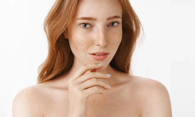 Ruda kobieta z piegami, których urok podkreśla naturalna produkcja melaniny.