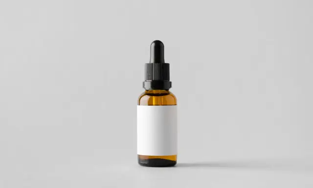 Brązowa buteleczka z pipetką, idealna na serum z witaminą E, np. tocopheryl acetate, z pustą białą etykietą.