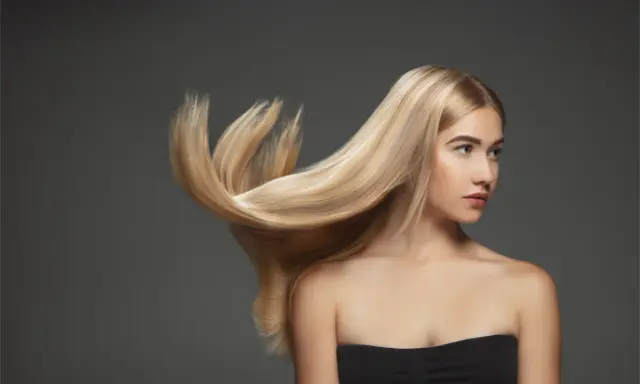 Blond włosy modelki falują, ukazując ich zdrową budowę.