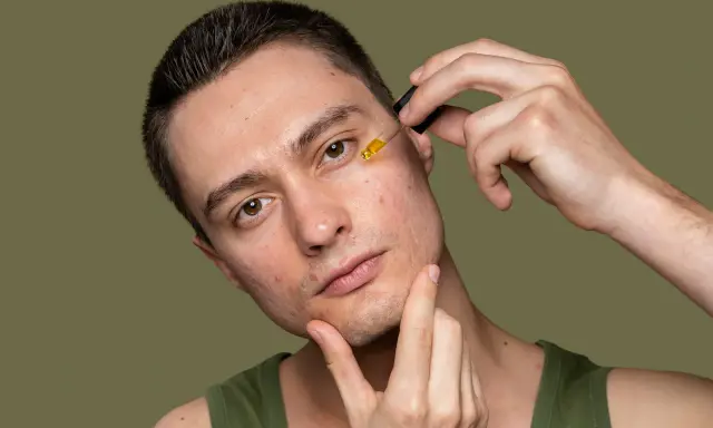 Mężczyzna z problematyczną cerą aplikuje serum. Zamiast wyciskanie wągrów, stawia na pielęgnację.